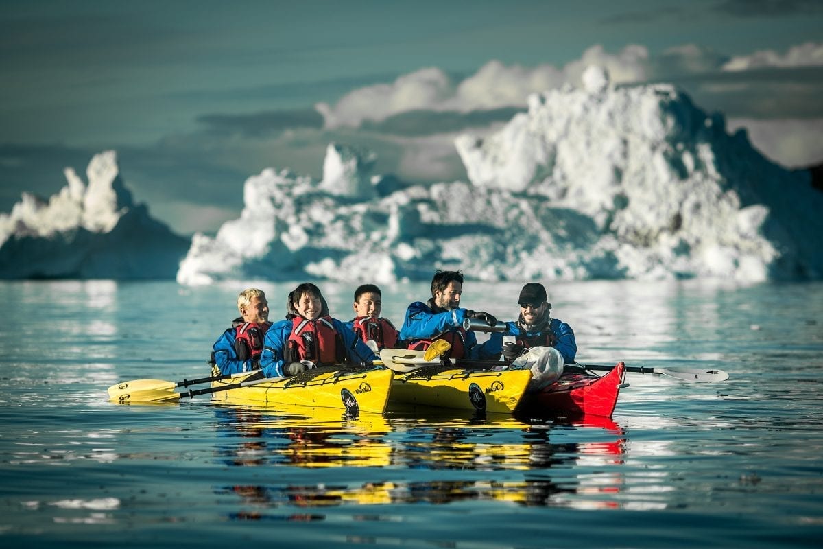 Pouring coffee on a kayaking trip among icebergs in the Disko Bay in Greenland